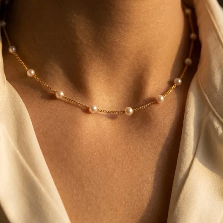 Colar de corrente de pérolas douradas com detalhes espaciais, marca Rose & Oliver, feito de material elegante e delicado.