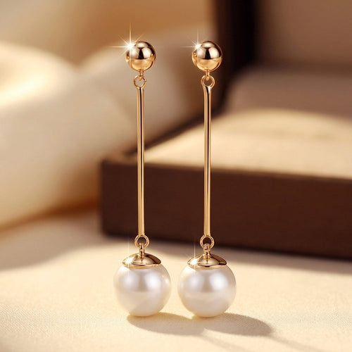 Brincos dourados com pérolas alongadas da marca Rose & Oliver, elegantes e sofisticados para ocasiões especiais.