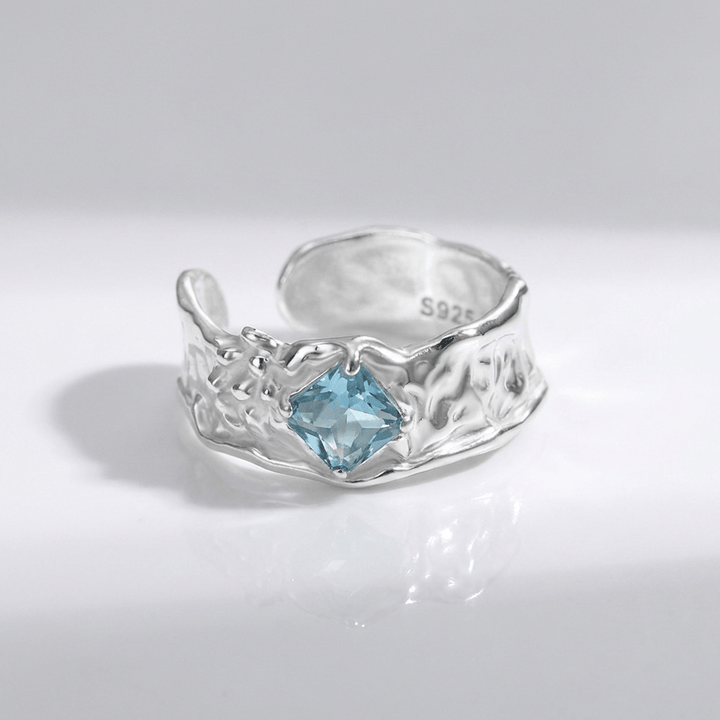 Anel ajustável com textura de água-marinha prateada, da marca Rose & Oliver, exibido com detalhes na superfície do anel.