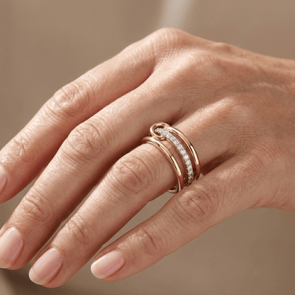 Anel de ouro com zircônia entrelaçada, joia delicada da marca Rose & Oliver, exibida em fundo neutro.