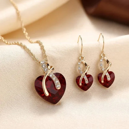 Rose & Oliver Schmuckset mit verdrehtem goldenen Herzen und roten Rubinen, einschließlich eleganter Halskette und Ohrringe für besondere Anlässe.