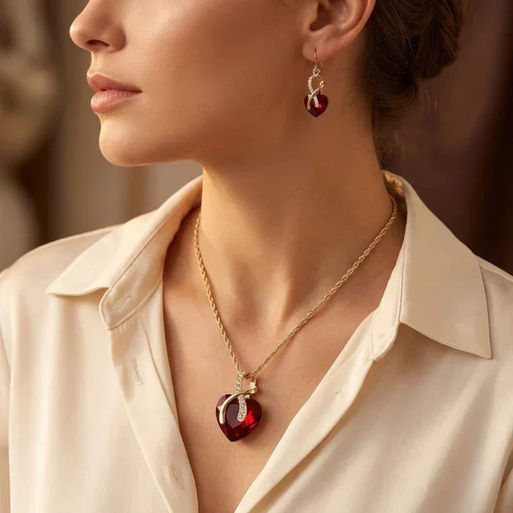 Rose & Oliver Schmuckset mit gedrehtem Herz in Gold und Rubinen, inklusive Ohrstecker und zarter Halskette mit roten Steinen.