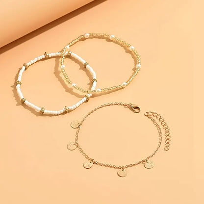 Set von 3 goldenen Fußketten Rose & Oliver Coastal Charm, mit Schichtdetails und zartem Design für den Knöchel.