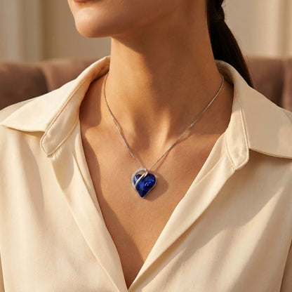 Colar de prata com pingente de coração com safira azul, da marca Rose & Oliver, exibido na imagem.