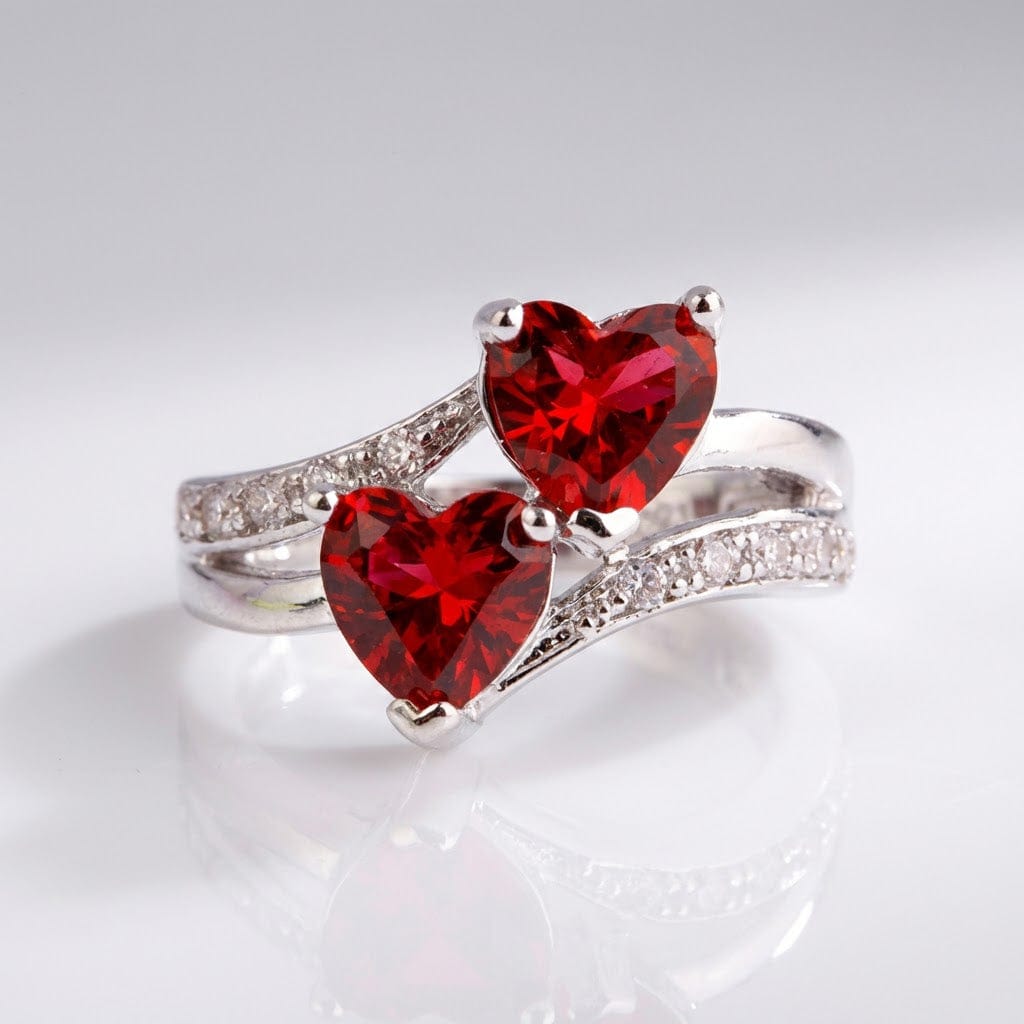 Anel de prata Rose & Oliver com dois corações vermelhos entrelaçados, design delicado para uso diário e ocasiões especiais.