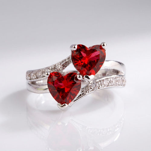 Anel de prata Rose & Oliver com dois corações vermelhos entrelaçados, design delicado para uso diário e ocasiões especiais.