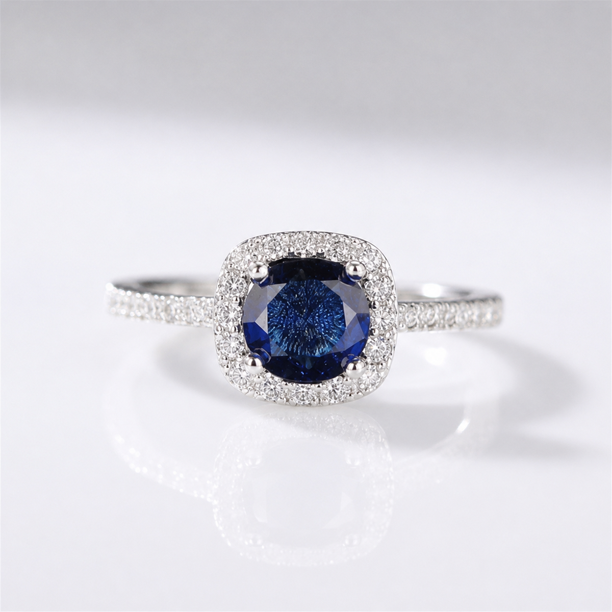 Anel de safira azul em corte cushion com halo de diamantes, produzido pela Rose & Oliver.