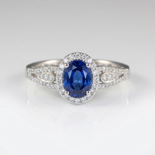 Anel vintage Rose & Oliver com halo de safira azul e detalhes em prata, destaque para o design elegante e pedra central brilhante.