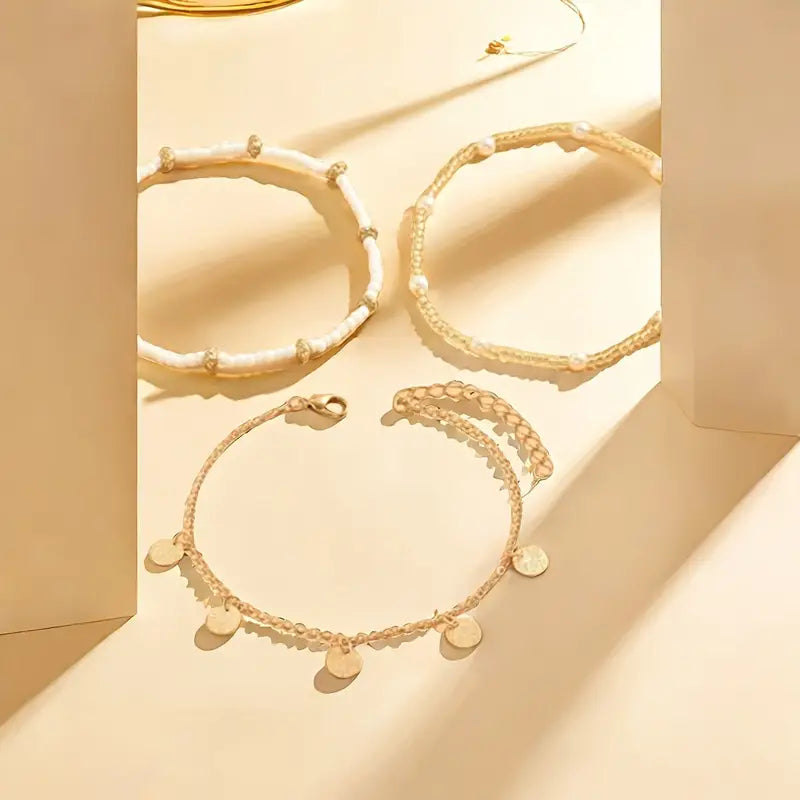 Set aus 3 goldenen Fußketten Rose & Oliver Coastal Charm, Layering-Stil, mit zarten Golddetails.