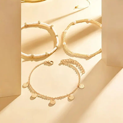 Set aus 3 goldenen Fußketten Rose & Oliver Coastal Charm, Layering-Stil, mit zarten Golddetails.