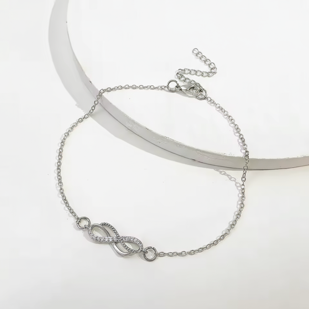 Zarte Silberanklet von Rose & Oliver mit Infinity-Anhänger, verstellbar und elegant, ideal zum Tragen am Knöchel.