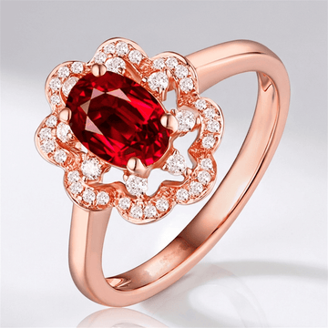 Anel de ouro rosé com rubi vermelho em halo, joia elegante da Rose & Oliver, destaque em dedo com detalhes brilhantes.