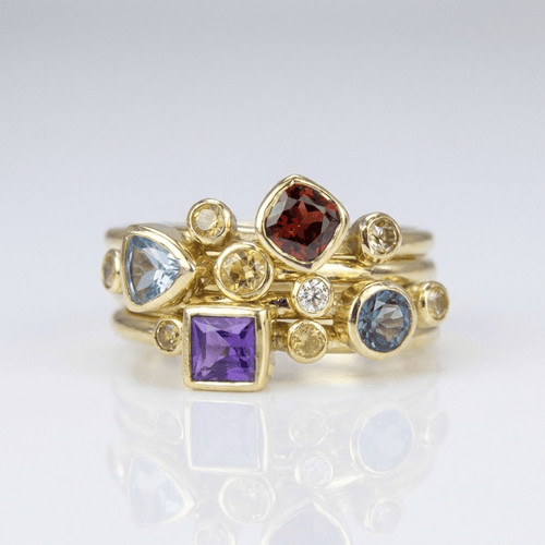 Stapelring-Set mit bunten Edelsteinen in Gold, Schmuck der Marke Rose & Oliver, zeigt lebendige und elegante Details.