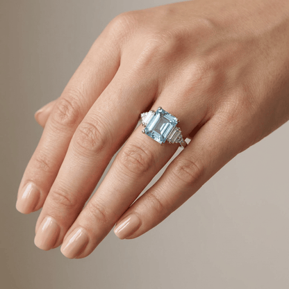 Anel de prata com três diamantes brilhantes, do design da marca Rose & Oliver, exibido em fundo neutro.