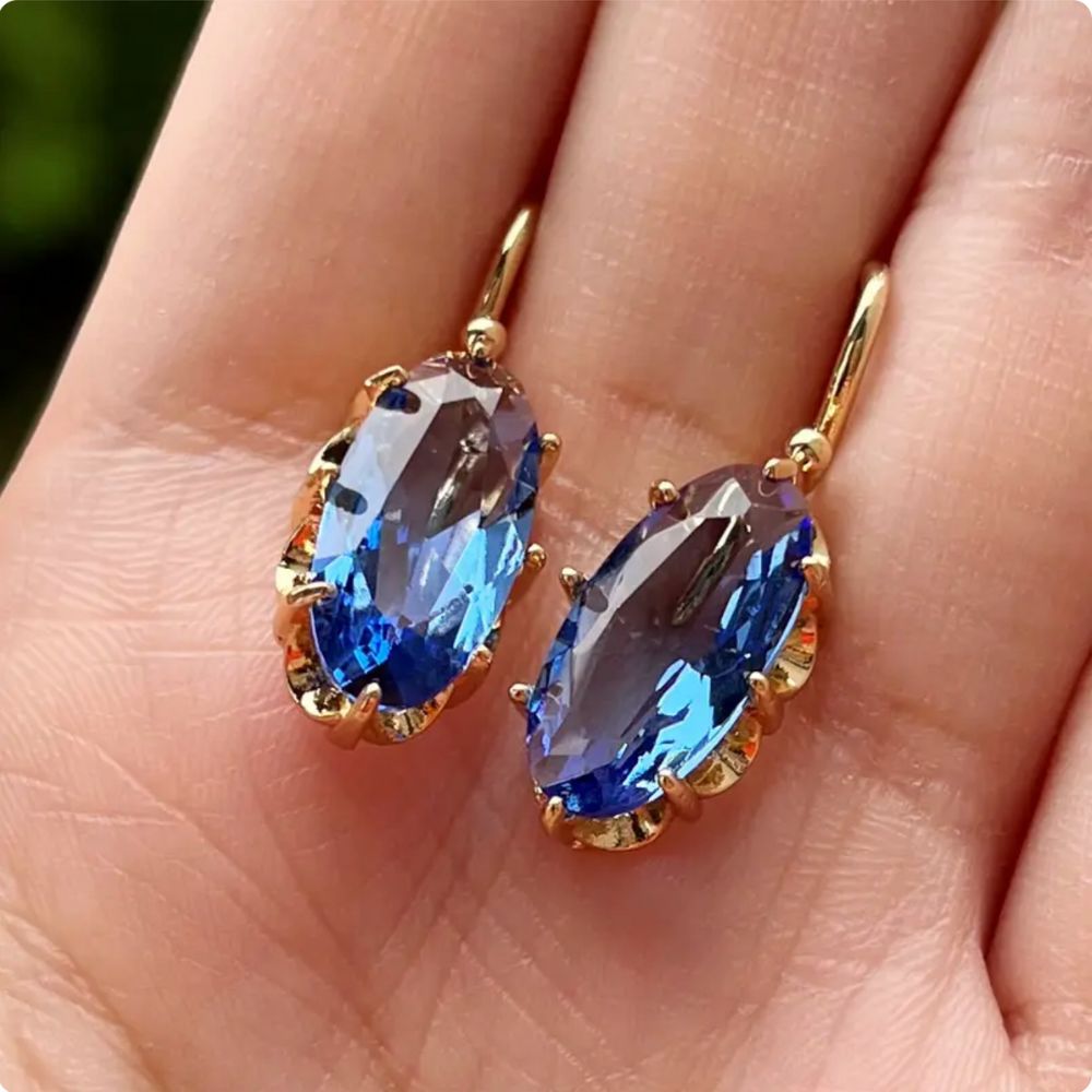 Goldene und blaue Ohrringe mit floralem Design der Marke Rose & Oliver, zarte Details und elegante Verarbeitung.